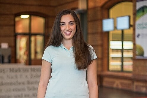 Praktikantin steht im Foyer eines Studentenwerks.