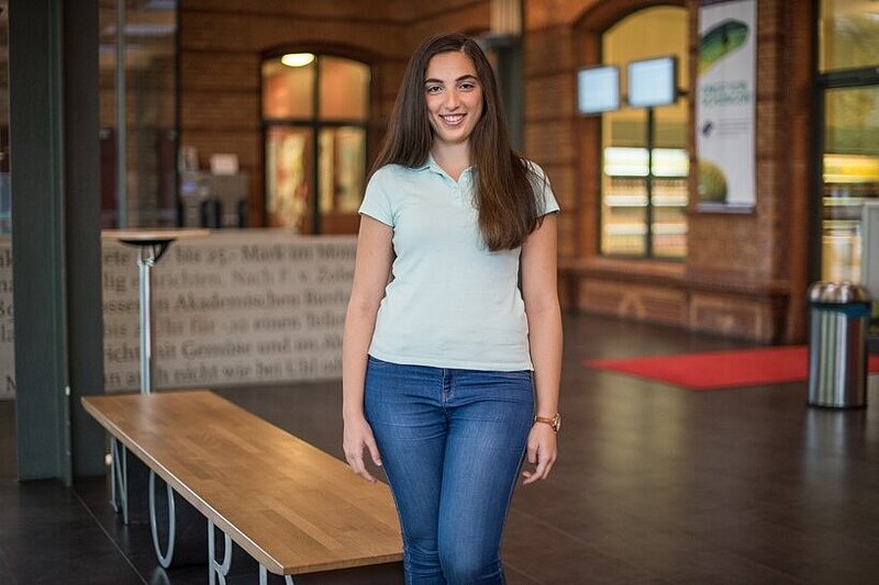 Praktikantin steht im Foyer eines Studentenwerks.