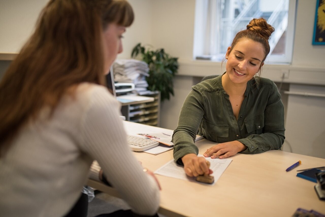 Eine Mitarbeiterin führt ein Beratungsgespräch mit einer Studierenden.