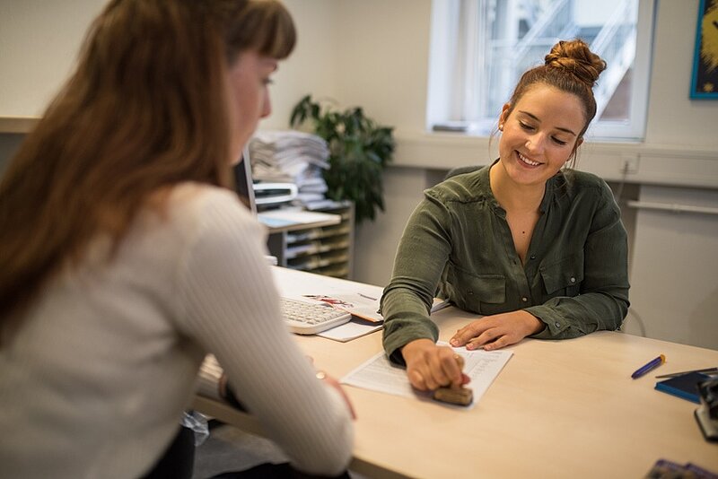 Eine Mitarbeiterin führt ein Beratungsgespräch mit einer Studierenden.