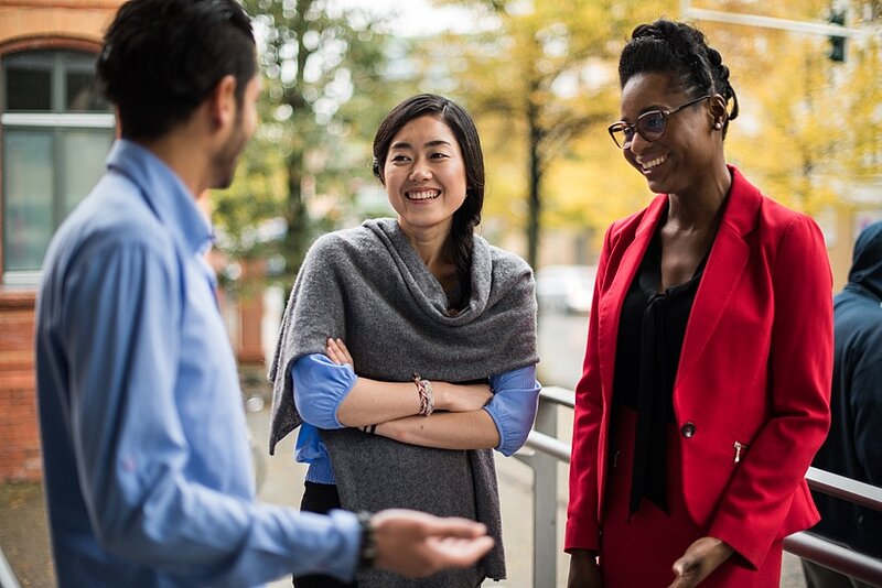 Internationale Studierende nehmen an einer Informationsveranstaltung teil und unterhalten sich.